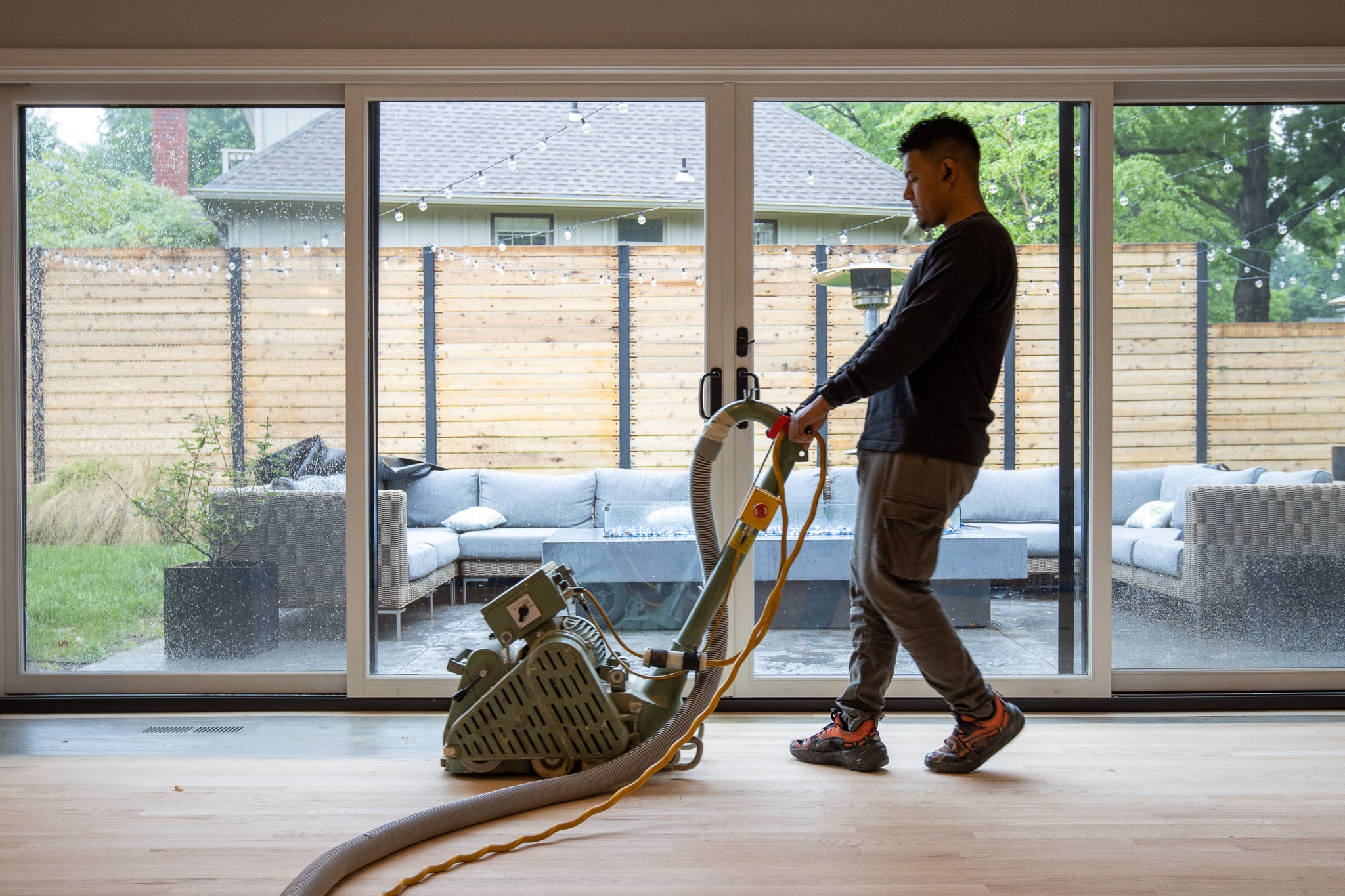 man sands hardwood floors in a kansas city home using Bona's dustless refinishing processes. Learn more about hardwood flooring sand and finish by calling SVB Wood Floors in Kansas City.