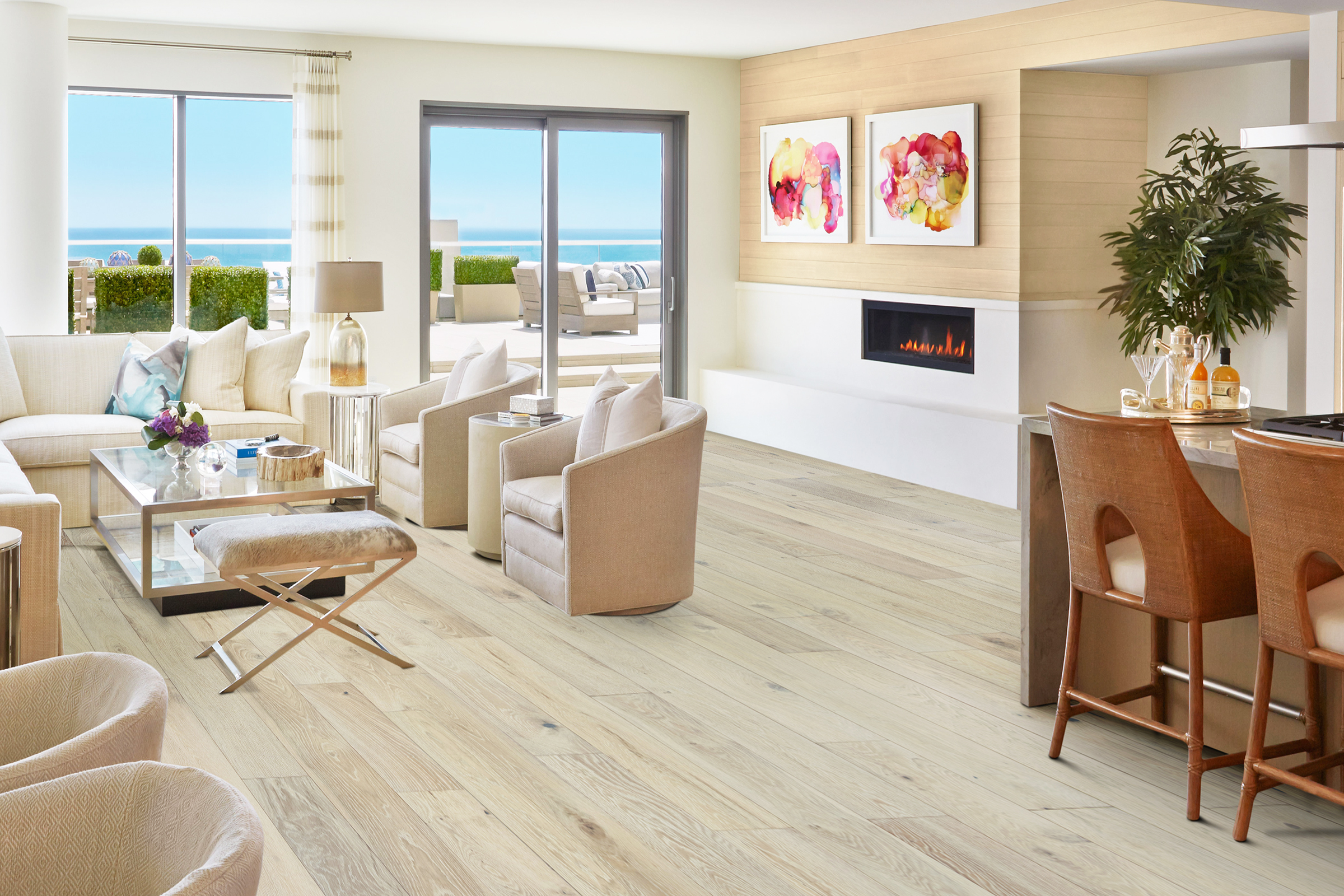 Bright coastal living room featuring pre-finished Lighthouse European White Oak flooring from SVB Wood Floors, modern furniture, ocean view, and stylish decor.