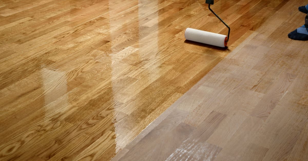 Hardwood floor recoating process with roller applying finish, showcasing restored shine and clarity in Kansas City hardwood flooring service.