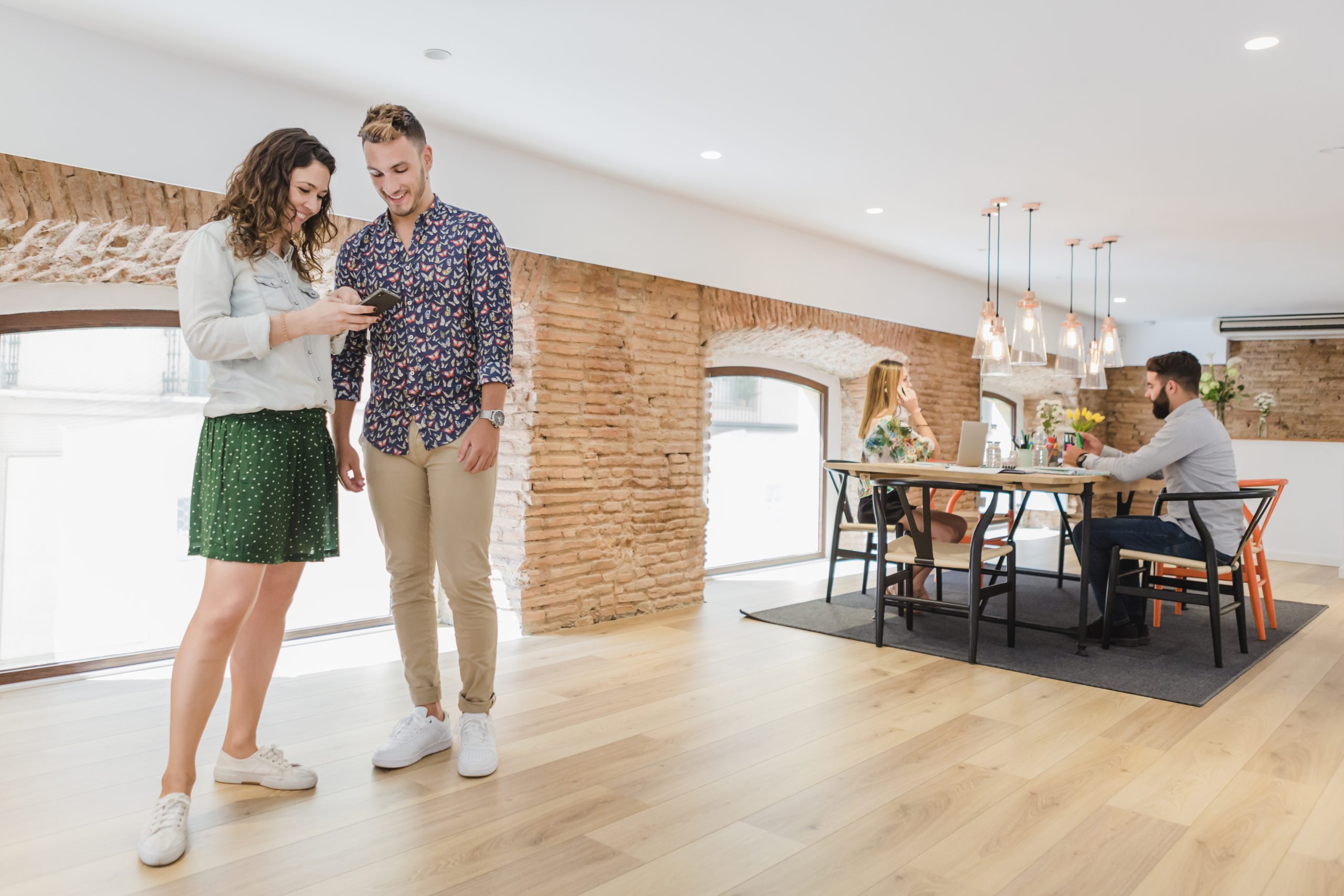 two people standing on wood floor engaged in a conversation