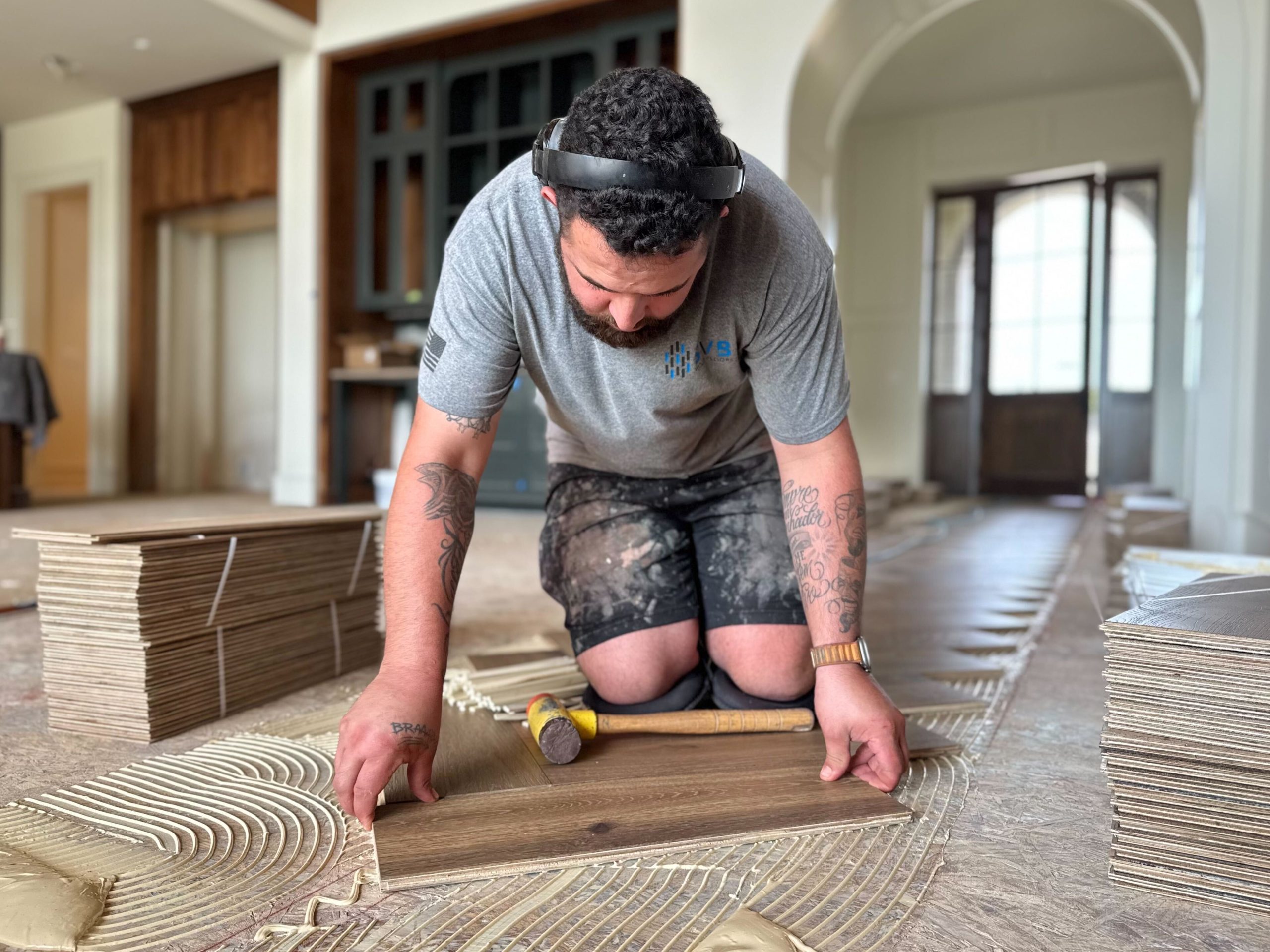 flooring contractor working on a wood floor installation in a residential home