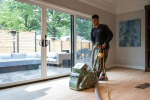 SVB worker performing dustless wood floor refinishing in a modern, residential Leawood Kansas home.
